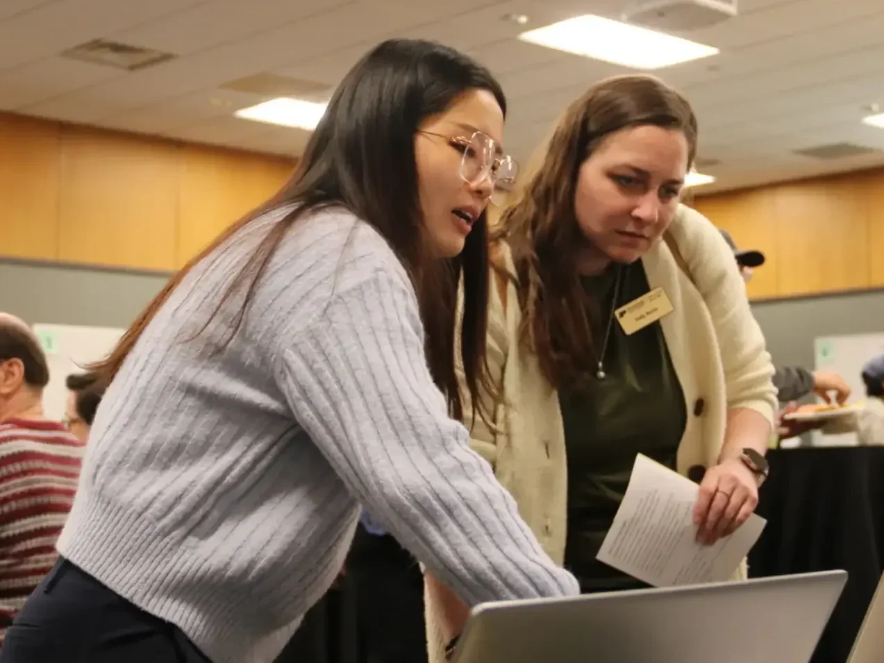 A Libraries faculty members showing a staff member something on a laptop.