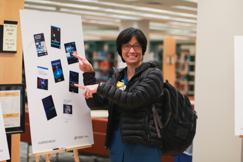 An author poses with her signature and book cover