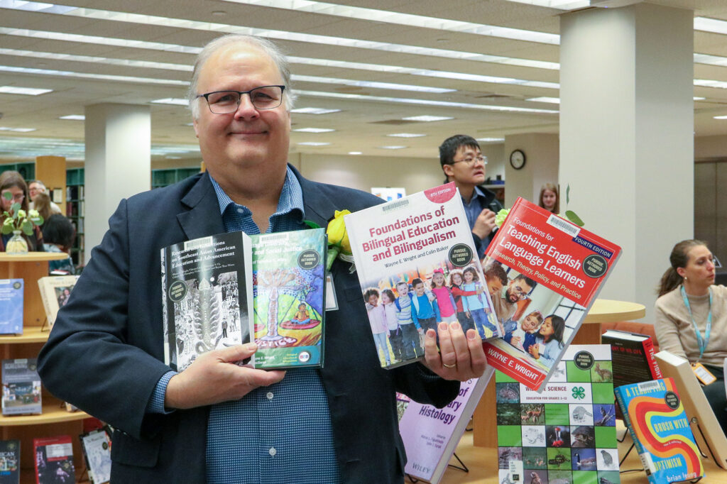 An author poses with his four books at the fall 2025 event