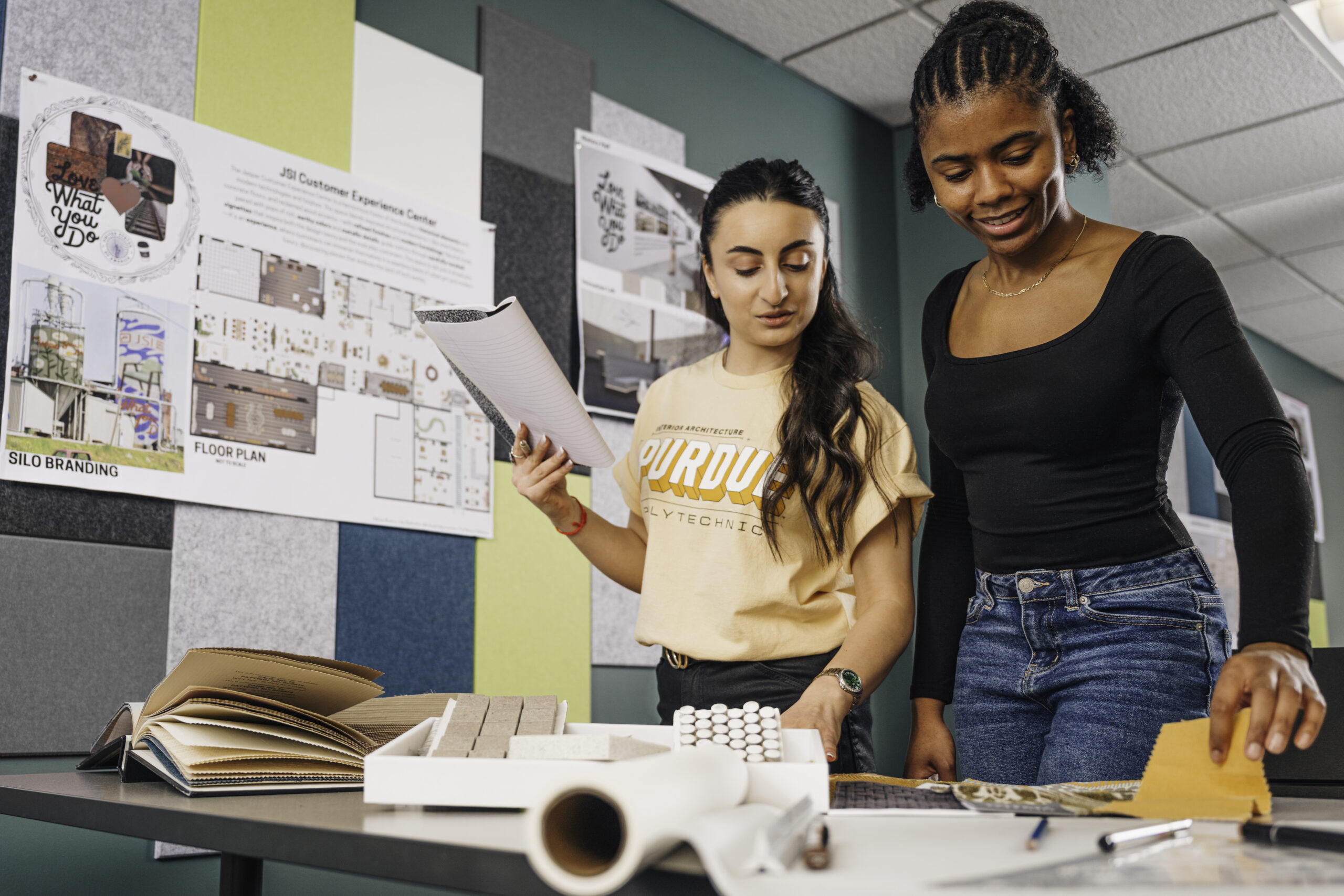 Two students collaborating at a design desk.