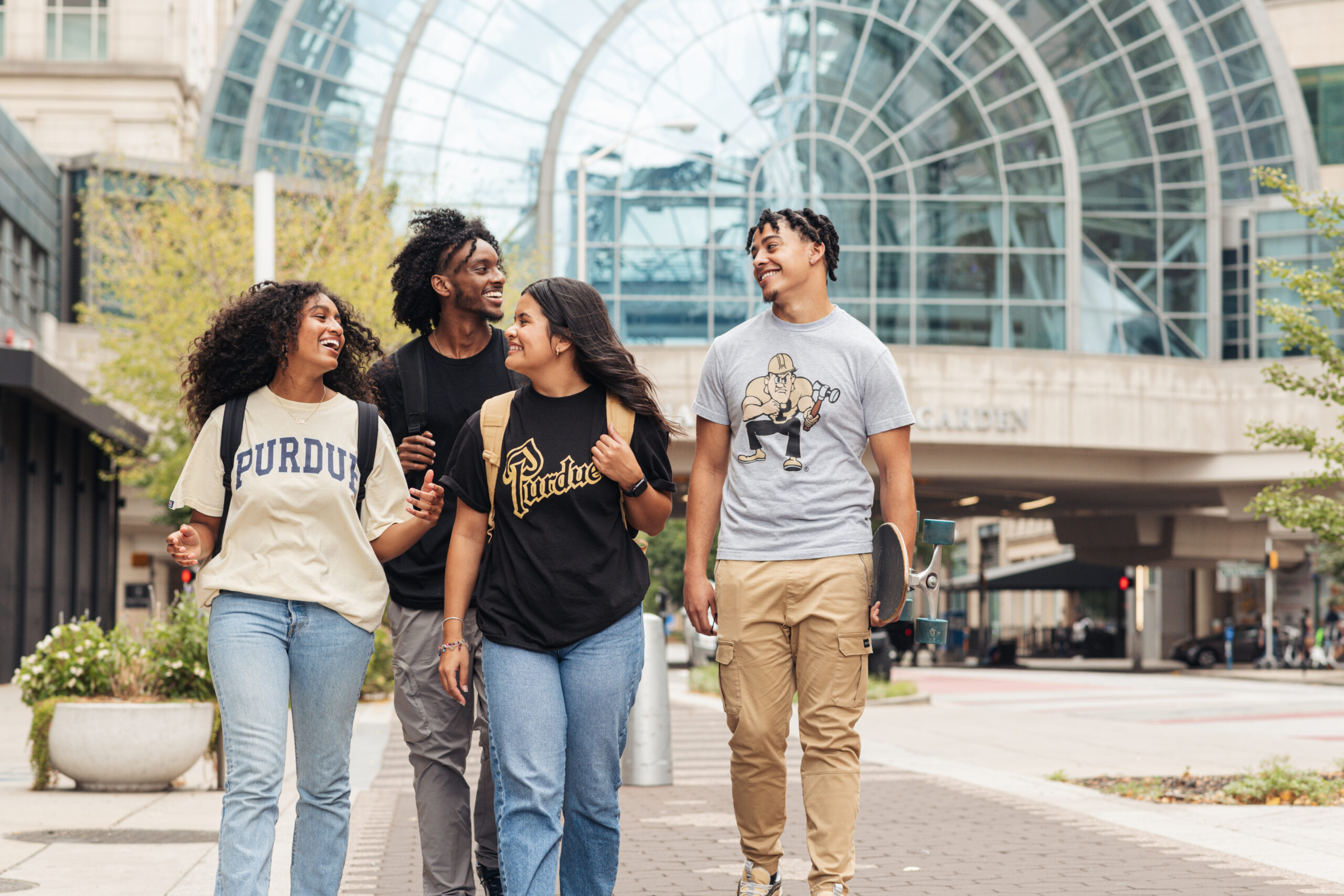 Four students walking and laughing together.